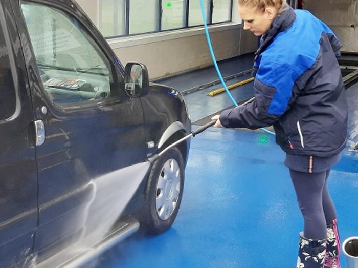 Een auto wordt met de hogedrukspuit gewassen in een van onze wasboxen